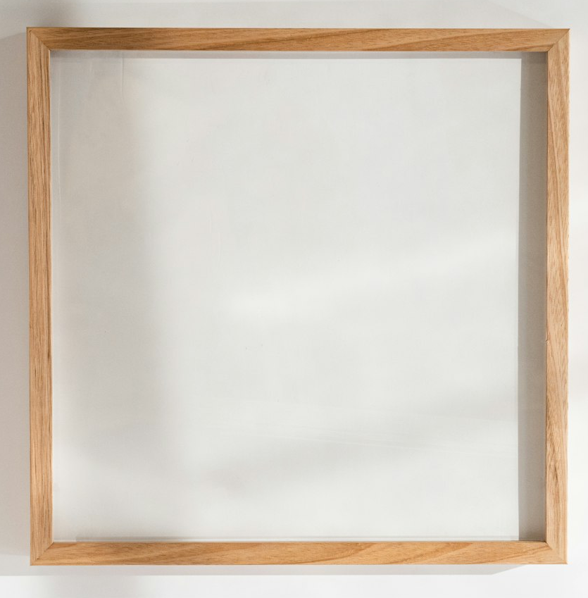 a square wooden frame hanging on a wall